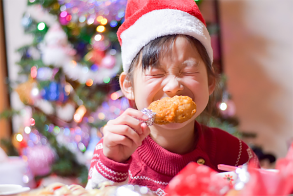KFC csirkeszombot evő japán kisgyerek mikulássapkában